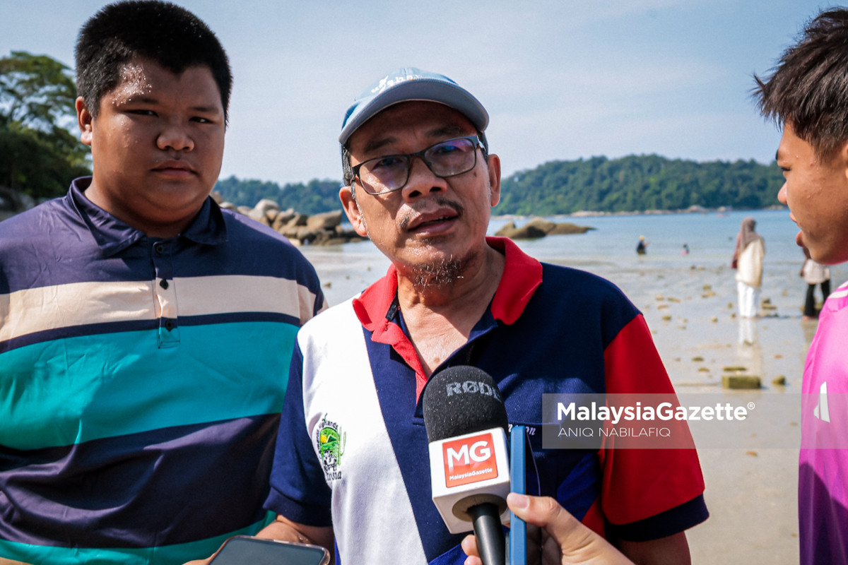 pengunjung jalan di laut terbelah Pulau Pangkor pengalaman laut terbelah Pulau Pangkor, Pantai Teluk Nipah Pangkor, jalan kaki ke Pulau Giam, fenomena alam Pulau Pangkor, pelancong teruja Pangkor, cuti perayaan Pulau Pangkor